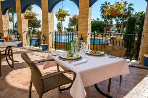 a table with a table cloth and chairs in front of a building at Hotel La Laguna Spa & Golf in Torrevieja