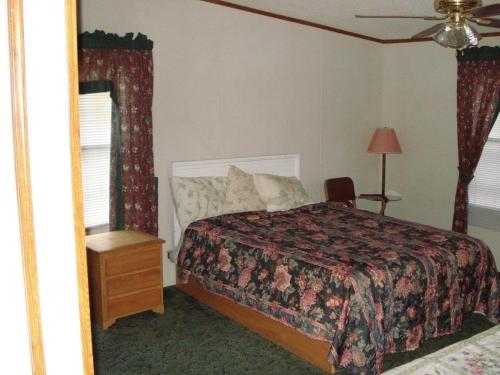 a bedroom with a bed and a chair and a mirror at Comfort Green Motel in Thayer
