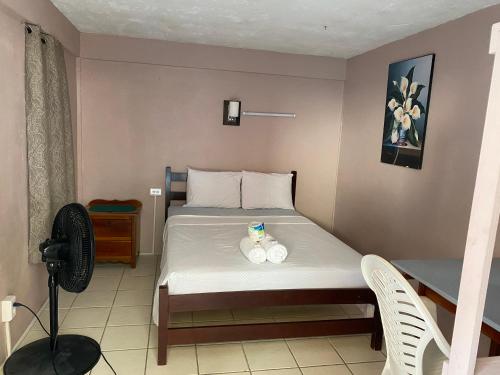 a bedroom with a bed with two dolls on it at Blue Wave Guest House in Caye Caulker