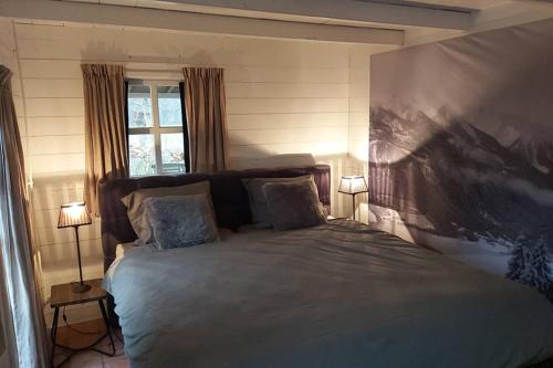 a bedroom with a large bed with a painting on the wall at Natuurhuis de LandJonker in Geesteren