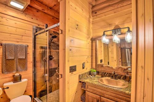 a bathroom with a toilet and a sink and a mirror at Luxury Mountain Cabin with Furnished Deck and Views! in Loma Linda