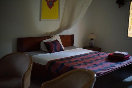 a bedroom with a bed and two chairs in it at Villa Amarant - Private Garden with Pool Retreat in Sanyang