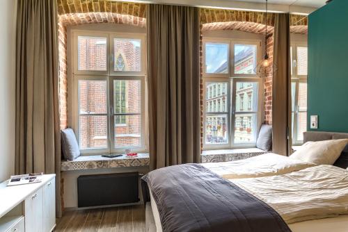 una camera da letto con tre finestre e un letto interno di 2/3 APARTMENTS Old Town a Breslavia