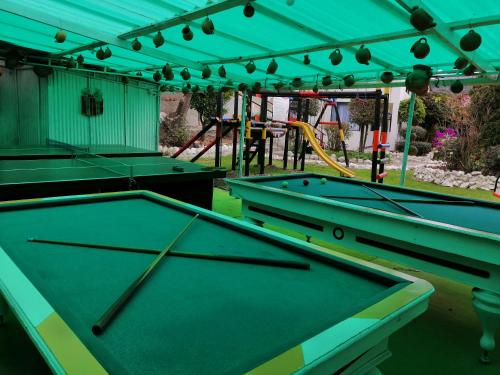 two pool tables in a yard with a playground at Hotel Casablanca Natural Spa in Paipa