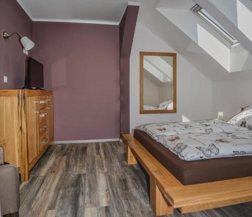 Schlafzimmer mit einem Bett und einem Spiegel in der Unterkunft Ta Fabrika Restavracija,pizzerija in prenočišča in Dravograd