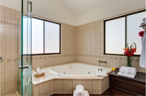 a bath tub in a bathroom with two windows at CC Beach Front Papagayo All Inclusive in Culebra