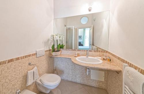 a bathroom with a sink and a toilet and a mirror at Villa Lieta in Ischia