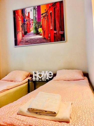 a bedroom with two beds and a picture on the wall at Noclegi AVATAR Radom in Radom