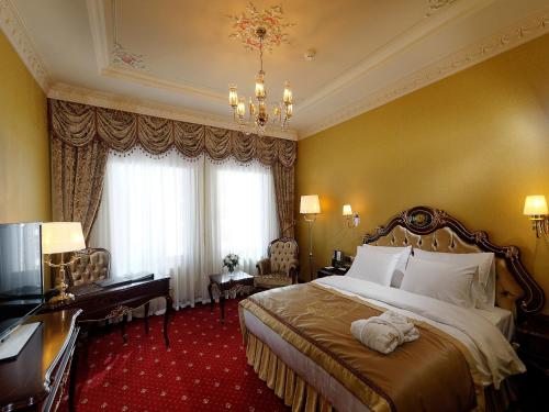 a hotel room with a large bed and a desk at Meyra Palace in Ankara