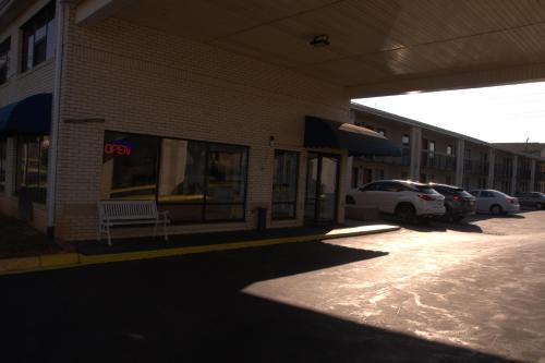 a building with a bench in front of a parking lot at Bestway Inn in Rock Hill