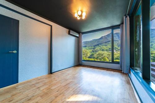 an empty room with a large window with a mountain view at Hooni Guest House & Motel in Gurye