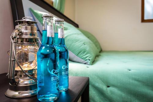 two blue bottles on a table next to a bed at Hooni Guest House & Motel in Gurye