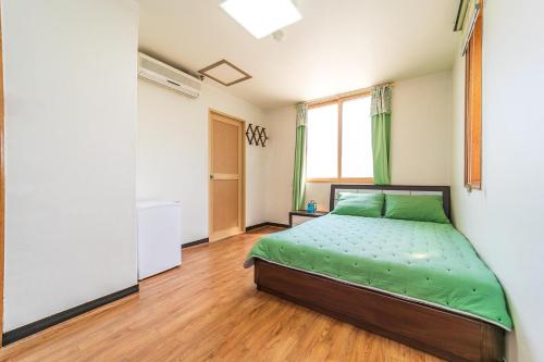 Un pat sau paturi într-o cameră la Hooni Guest House & Motel