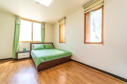 a bedroom with a bed and two windows at Hooni Guest House & Motel in Gurye
