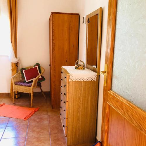 a room with a dresser and a door and a chair at Casa Camino Tamadaba in Agaete