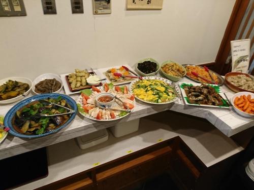 a table with a bunch of different plates of food at Toyohashi Station Hotel in Toyohashi