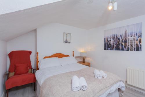 ein Schlafzimmer mit einem Bett und einem roten Stuhl in der Unterkunft Windsor House in Derry Londonderry