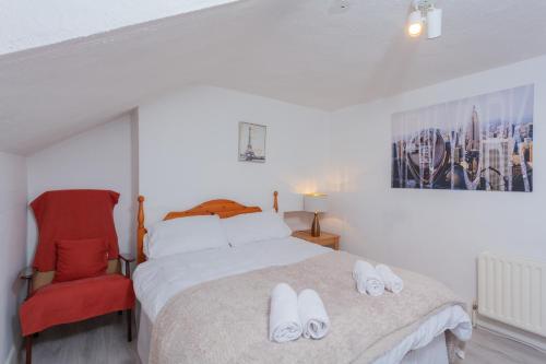 a bedroom with a bed and a red chair at Windsor House in Derry Londonderry