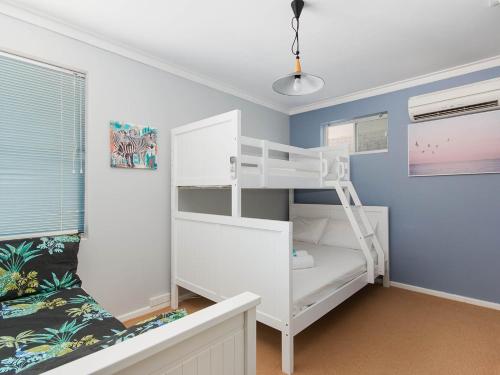 a white bunk bed in a room with a couch at Twin Waters Caravan Park in Dawesville