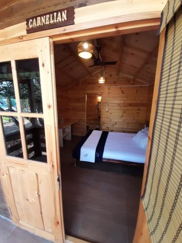 a room with a bed in a wooden cabin at Cocorico Stay Ya! Cottages Alibag in Alibaug