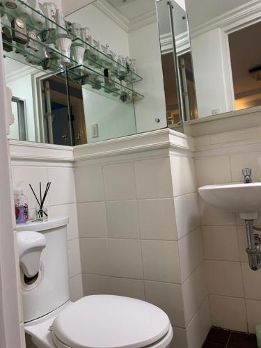 a bathroom with a toilet and a sink and a mirror at Northpoint Camella Condo Suites in Davao City