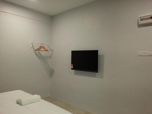 Cette chambre blanche dispose d'une télévision murale. dans l'établissement L Hotel, à Simpang Renggam