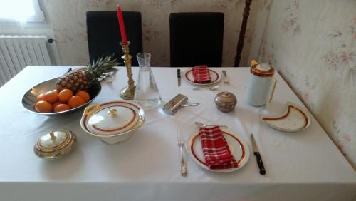 - une table avec des assiettes et un bol de fruits dans l'établissement Chambre au calme et simple, cuisine à dispo, à Saint-Pol-de-Léon