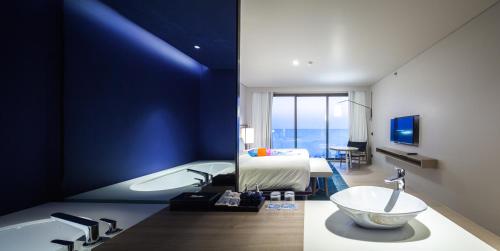 1 dormitorio con 1 cama y baño con bañera. en Veranda Resort Pattaya - MGallery by Sofitel en Jomtien Beach