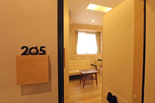 a door to a room with a table and a chair at Hotel 3 O'Clock Tennoji in Osaka