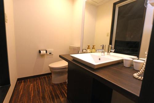 a bathroom with a sink and a toilet at Hotel 3 O'Clock Tennoji in Osaka