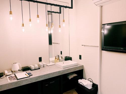 a bathroom with a sink and a large mirror at Hotel 3 O'Clock Tennoji in Osaka
