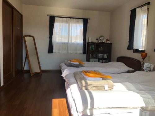 岐阜市にあるゲストハウス 岐阜 SUAIのベッドルーム1室(ベッド2台、テーブル、鏡付)