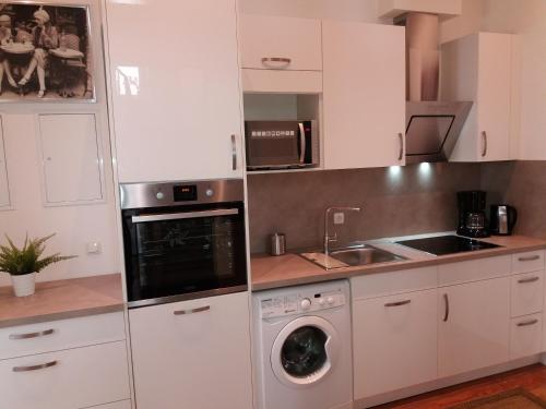 a kitchen with white cabinets and a washing machine at Apartment Comfort in Worms