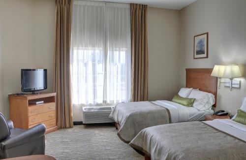 a hotel room with two beds and a television at Candlewood Suites Texarkana by IHG in Texarkana - Texas