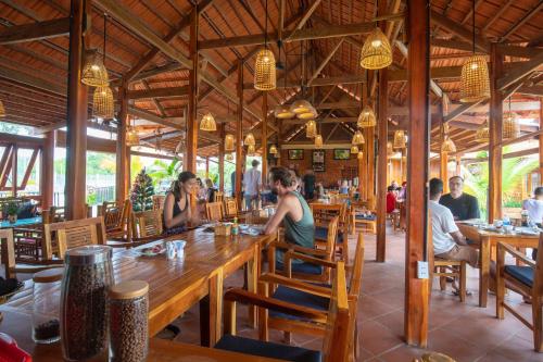 a group of people sitting at a table in a restaurant at Island Lodge in Phu Quoc