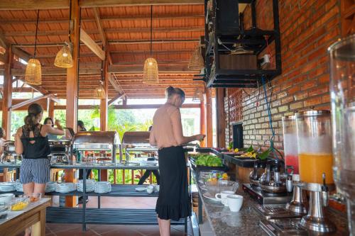two women standing in a kitchen preparing food at Island Lodge in Phu Quoc