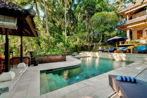 a swimming pool in a backyard with a house at Kebun Indah Ubud in Ubud