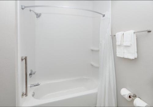 a bathroom with a shower and a bath tub with towels at Holiday Inn Express & Suites - Plano - The Colony by IHG in The Colony