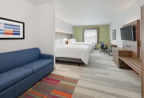 a hotel room with a bed and a couch at Holiday Inn Express & Suites - Plano - The Colony by IHG in The Colony