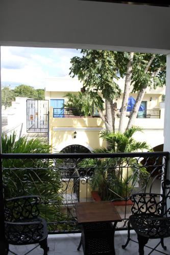 a balcony with a table and chairs and a tree at Hotel Casona Margot in Valladolid