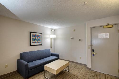 a waiting room with a blue couch and a table at Holiday Inn Express Hotel & Suites Oshkosh - State Route 41 by IHG in Oshkosh