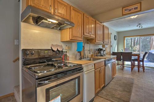 a kitchen with wooden cabinets and a stove top oven at Hike, Ski and Golf Private Poconos Cabin with Deck! in Tobyhanna