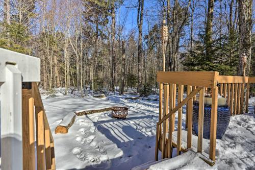 a snow covered yard with a wooden fence and trees at Hike, Ski and Golf Private Poconos Cabin with Deck! in Tobyhanna