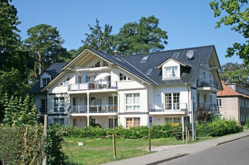 a white house with a black roof at Villa Mara Wohnung 09 mit Balkon in Baabe