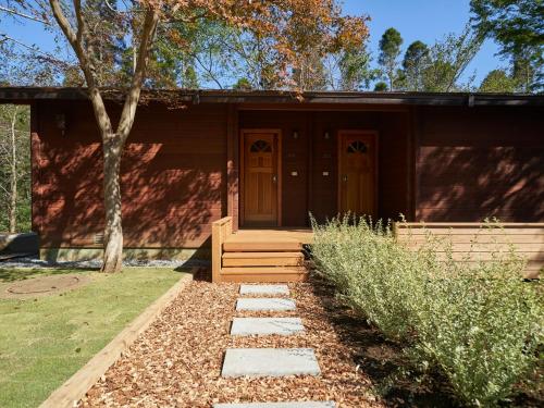 a small house with brown doors in a yard at Resol no Mori in Nagara