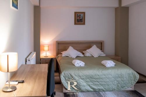 a bedroom with a bed with a desk and a bed sidx sidx sidx at Apartament Modern Rivulus 28 in Baia Mare