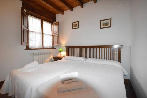 a bedroom with a white bed with two towels on it at Apartamentos La Huertina in Canales