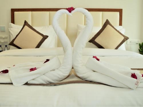 two swans towels sitting on top of a bed at Hotel Siddhartha Inn in Udaipur