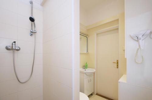 a white bathroom with a shower and a toilet at Flamingo Apartments in Prague