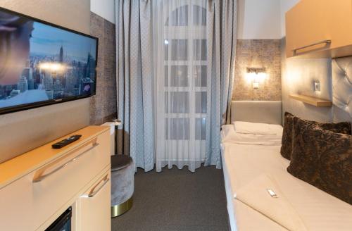 Pokój z telewizorem i oknem z kanapą w obiekcie Teátrum Boutique Hotel w Győr